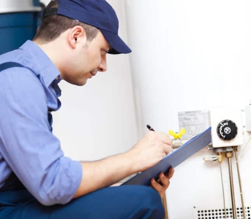 Hot Water Heater venting Technician inspecting a hot water heater